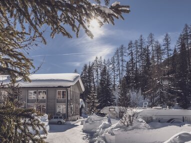 Verschneites Hostel mit Sonne und blauem Himmel | © Davos Klosters Mountains