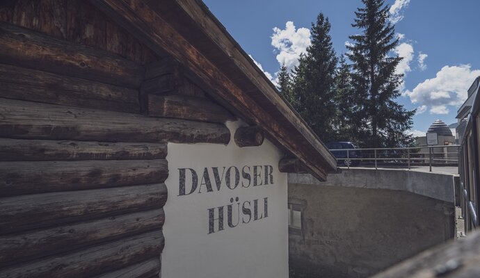 Aussenansicht eines Chalet mit Tannen im Hintergrund | © Davos Klosters Mountains 
