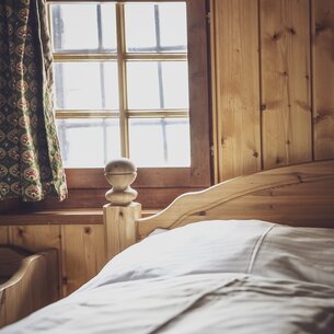 Hotelbett mit kleinem Fenster | © Davos Klosters Mountains