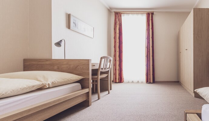 Glance into a simple twin room at the Josephs House. | © Davos Klosters Mountains