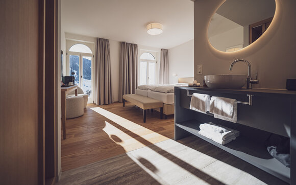 helles Doppelbettzimmer mit Lavabo und Sitzgelegenheit | © Davos Klosters Mountains 