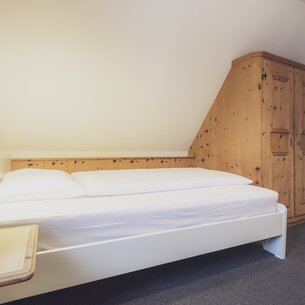 Hotel bed with bedside table | © Davos Klosters Mountains