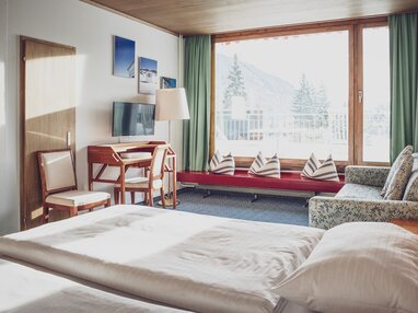 Helles Familienhotelzimmer mit Schreibtisch | © Davos Klosters Mountains