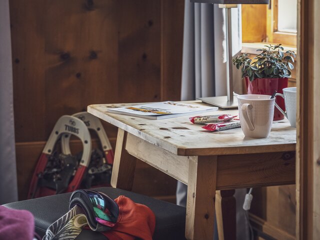 Schreibtisch im Hotelzimmer mit Schneeschuhen und Skibrille | © Davos Klosters Mountains