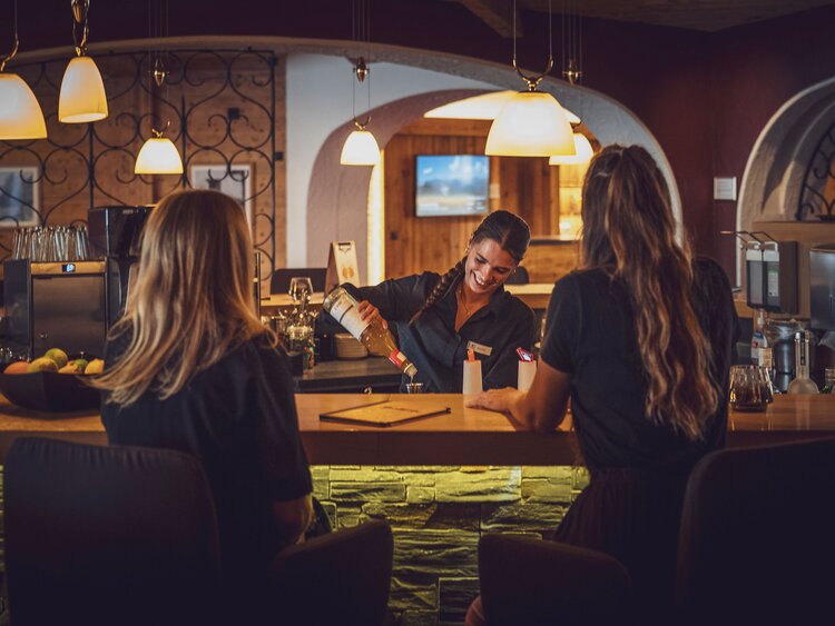 Bartender serving drinks to girl friends at Mountain Bar at Mountnain Plaza Hotel Davos | © Davos KLosters Bergbahnen AG