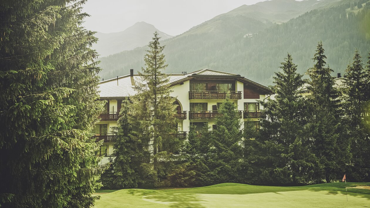Mehrstöckiges Gebäude mit Balkonen umringt von Nadelbäumen  | © Davos Klosters Mountains 