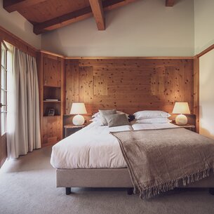 Hotelzimmer mit Doppelbett und offener Balkontür | © Davos Klosters Mountains
