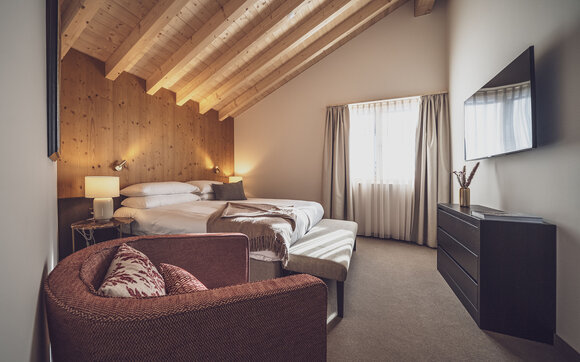 Blick in die helle Senior Suite im Hotel Waldhuus, die in warmen Tönen ausgestattet ist. | © Davos Klosters Mountains